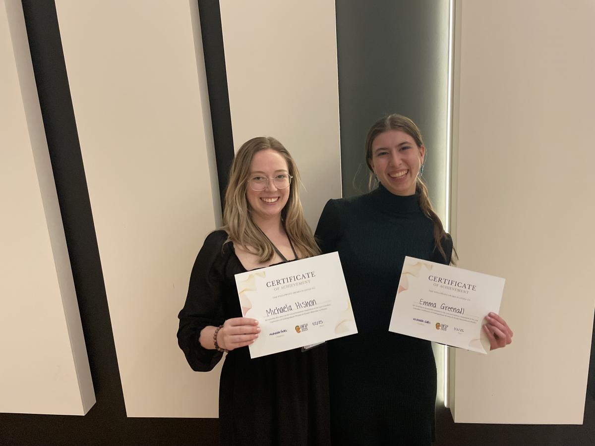 Michaela and Emma posing together with their conference certificates